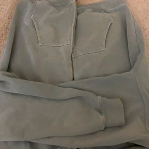 Basic, zip-up hoodie in sage green with two pockets and a drawstring hood.